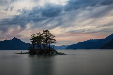 Huysuz bir gökyüzü sırasında arka planda Howe ses bir ada Dağları ile görünümü güzel manzara. Tüylü Creek, Vancouver, British Columbia, Kanada kuzeyindeki alınan.