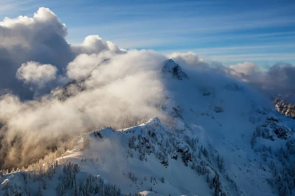 Aerial landscape view of the coastal mountains north of Vancouver, British Columbia, Canada, during a cloudy winter evening.