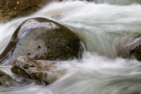 Stromend water rond de zachte rotsen — Stockfoto
