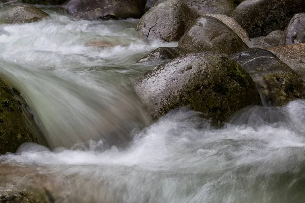 Stromend water rond de zachte rotsen — Stockfoto