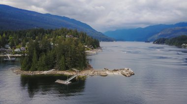 Gri taş ada derin Cove, North Vancouver, British Columbia, Kanada. Hava perspektif bulutlu bir akşam sırasında alınan.