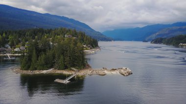 Gri taş ada derin Cove, North Vancouver, British Columbia, Kanada. Hava perspektif bulutlu bir akşam sırasında alınan.