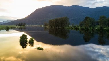 Bir nehir dağlardaki yansıma bulutlu bir altın gün batımı sırasında. Fraser Valley, British Columbia, Kanada Nicomen Slought alınan.