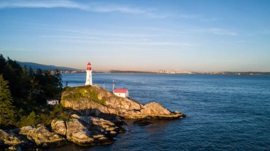 Havadan görünümü ışık evin bir kayalık kıyısında. Deniz feneri Park, Batı Vancouver, British Columbia, Kanada, güneşli bir gün batımı sırasında alınan.