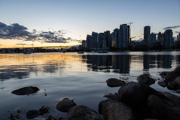 岩石海岸在一个公园在错误小河与街市温哥华 加拿大 在背景在日落期间 — 图库照片
