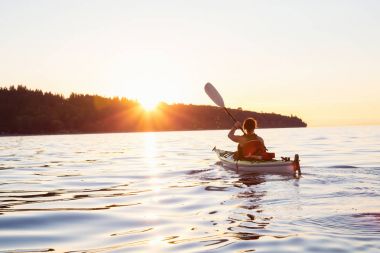Günbatımı sırasında Kayak kız