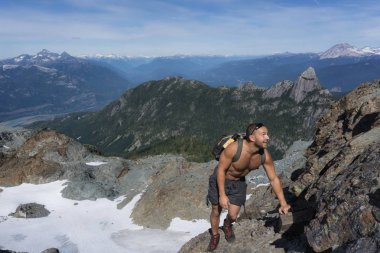 Uygun genç beyaz maceracı biri dik kaya levha bir güzel yaz günü sırasında tırmanıyor. Skypilot dağ yakınındaki Squamish, Kuzey Vancouver, Bc, Kanada için yokuş üzerinde alınan resim.