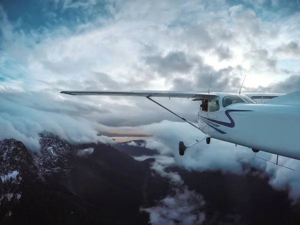 Dağlarda bulutlu gökyüzü uçan uçak — Stok fotoğraf