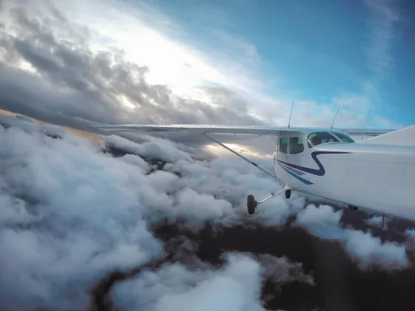 Avião voando no céu nublado em torno de montanhas — Fotografia de Stock
