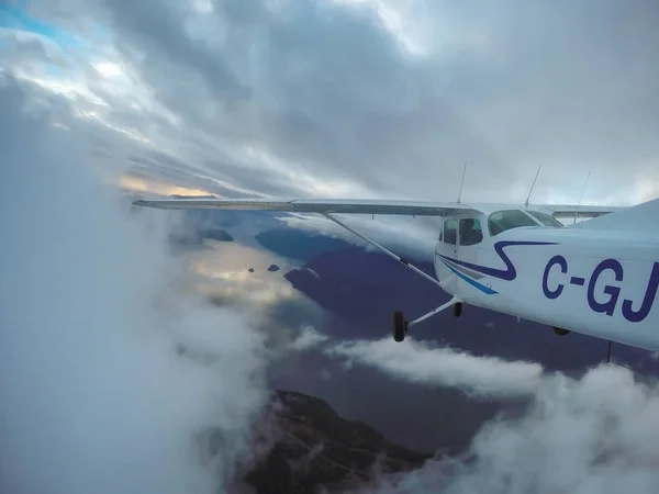 Dağlarda bulutlu gökyüzü uçan uçak — Stok fotoğraf