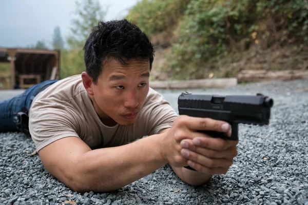 Asiatico Giovane Uomo Ghiaia Terra Posa Posizione Holding Pistola Mirare — Foto Stock