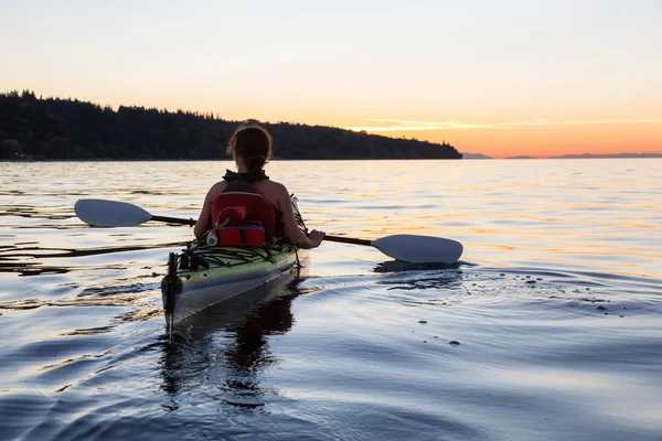 Flicka som kajakpaddling under solnedgången — Stockfoto