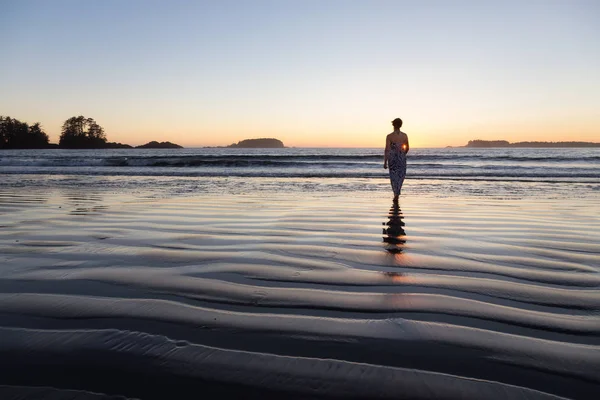 日落时分在大海中漫步的女子的后观 — 图库照片
