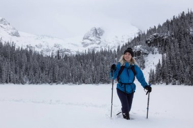 Macera kadın güzel Kanada kar kaplı manzara içinde kış döneminde snowshoeing. Joffre Gölü, Vancouver, British Columbia, Kanada kuzeyindeki alınan.