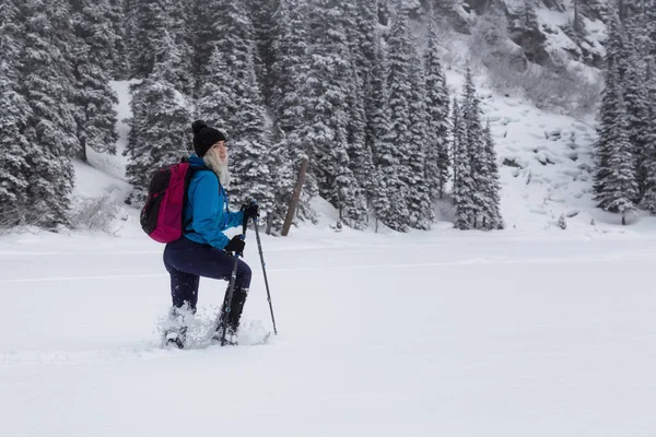 冒险的女人是雪地行走在美丽的加拿大雪覆盖的景观在冬季的时间 在加拿大不列颠哥伦比亚省温哥华以北的霞飞路湖拍摄 — 图库照片