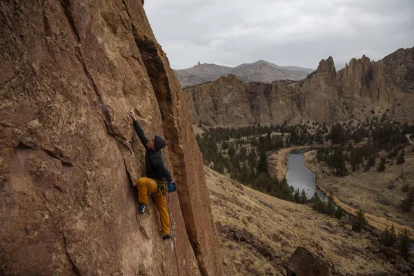 Adventurous Man Rock Climbing Side Steep Cliff Cloudy Winter Evening — Stock Photo, Image