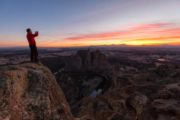站在山顶上的人在丰富多彩的日落中享受着美丽的风景 拍摄于美国俄勒冈州的史密斯摇滚 — 图库照片