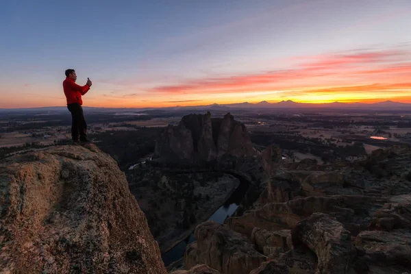站在山顶上的人在丰富多彩的日落中享受着美丽的风景 拍摄于美国俄勒冈州的史密斯摇滚 — 图库照片