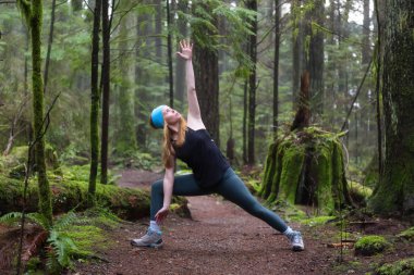 Genç beyaz kız yağmur ormanlarında yoga pratiği yapıyor. Alınan Capilano Kanyon, North Vancouver, Bc, Kanada.