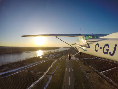Pitt Meadows, büyük Vancouver, British Columbia, Kanada - 22 Şubat 2018 - küçük uçak, Cessna 172, canlı bir kış aylarında pist günbatımı alarak.