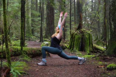 Genç beyaz kız yağmur ormanlarında yoga pratiği yapıyor. Alınan Capilano Kanyon, North Vancouver, Bc, Kanada.