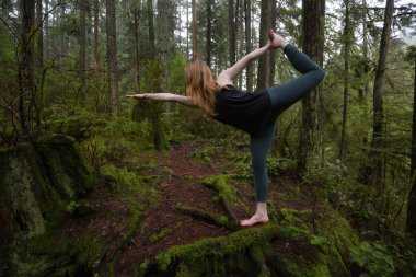 Genç beyaz kız yağmur ormanlarında yoga pratiği yapıyor. Alınan Capilano Kanyon, North Vancouver, Bc, Kanada.