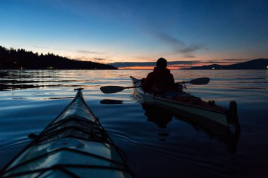 Adam kanosu canlı bir gün batımı sırasında deniz kayağı üzerinde. Alınan Jericho Beach, Vancouver, British Columbia, Kanada.