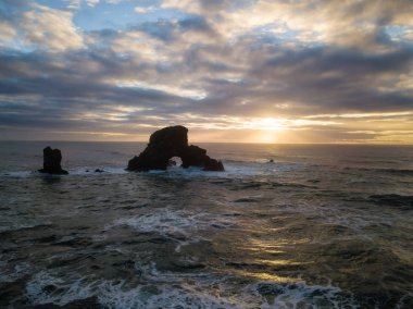 Striking and Dramatic Panoramic Aerial View of the Rock Pacific Ocean during a Vibrant Winter Sunset. Taken in Oregon Coast, North America. clipart