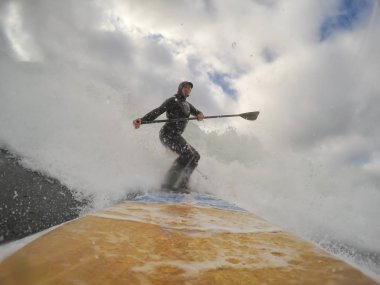 Adam bir stand-up kürek tahtada okyanusta kürek çekmeye. Estevan, Vancouver Adası, British Columbia, Kanada alınan.