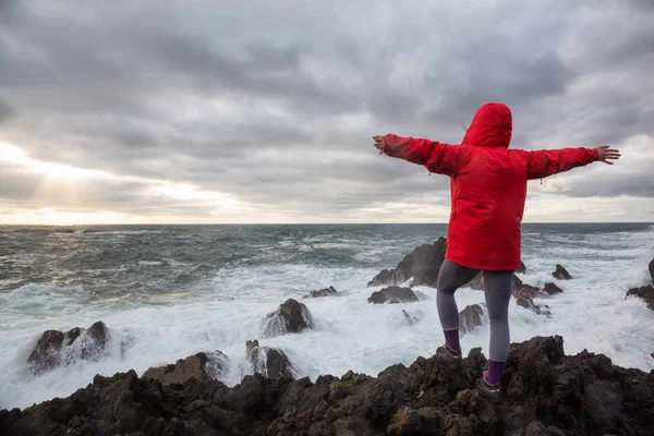 穿着鲜艳红色夹克的女人正在看海浪在岩石的太平洋沿岸坠毁 乌克雷特 温哥华岛 加拿大不列颠哥伦比亚省 — 图库照片