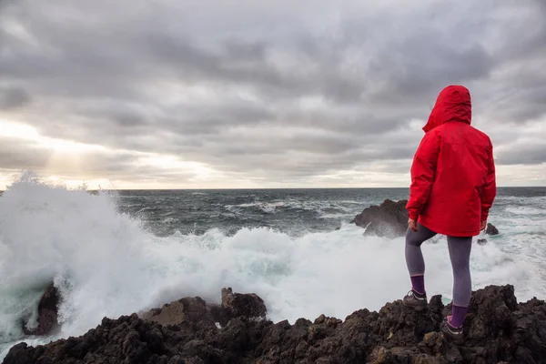 穿着鲜艳红色夹克的女人正在看海浪在岩石的太平洋沿岸坠毁 乌克雷特 温哥华岛 加拿大不列颠哥伦比亚省 — 图库照片