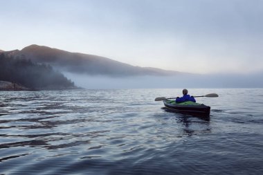 Maceracı kadın canlı kış günbatımı sırasında şişme bir kayık macera aktivite var. Horseshoe Bay, Batı Vancouver, Bc, Kanada çekilmiş. Konsept: Macera, tatil, tatil, keşfetmek