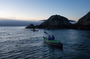 Maceracı kadın canlı kış günbatımı sırasında şişme bir kayık macera aktivite var. Horseshoe Bay, Batı Vancouver, Bc, Kanada çekilmiş. Konsept: Macera, tatil, tatil, keşfetmek