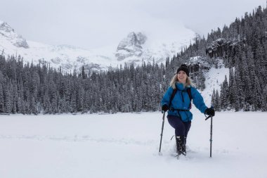 Macera kadın güzel Kanada kar kaplı manzara içinde kış döneminde snowshoeing. Joffre Gölü, Vancouver, British Columbia, Kanada kuzeyindeki alınan.