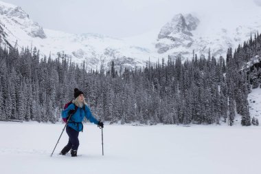 Macera kadın güzel Kanada kar kaplı manzara içinde kış döneminde snowshoeing. Joffre Gölü, Vancouver, British Columbia, Kanada kuzeyindeki alınan.