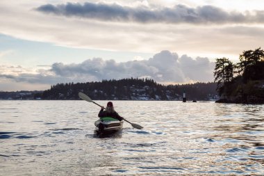 Maceracı kız canlı kış günbatımı sırasında şişme bir kayık Kayak. Hint kol, derin koyu, Vancouver, Bc, Kanada içinde alınan. Konsept: Macera, tatil