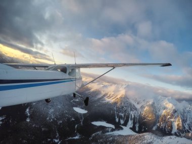 Küçük uçak uçuş sırasında canlı bir günbatımı güzel Kanada dağ manzara katmayın. Vancouver, British Columbia, Kanada kuzeyindeki alınan.