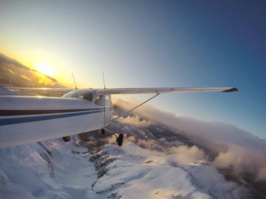Küçük uçak uçuş sırasında canlı bir günbatımı güzel Kanada dağ manzara katmayın. Vancouver, British Columbia, Kanada kuzeyindeki alınan.
