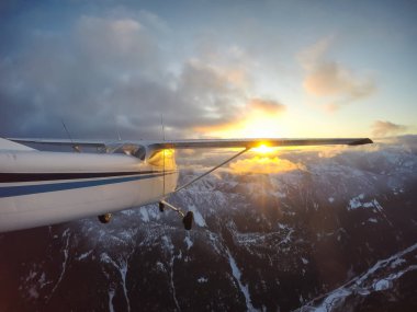 Küçük uçak uçuş sırasında canlı bir günbatımı güzel Kanada dağ manzara katmayın. Vancouver, British Columbia, Kanada kuzeyindeki alınan.