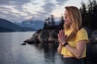 Arabuluculuk positiong genç kız günbatımı sırasında huzurlu an keyif alıyor. Whytecliff park, Horseshoe Bay, Vancouver, Bc, Kanada içinde alınan.