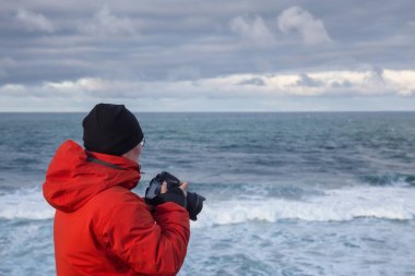 Maceracı bir kamera ile ayakta resimlerini güzel okyanus sırasında canlı kış sabahı adamdır. Cape Kiwanda, Pacific City, Oregon kıyılarında, Amerika'da alınan.