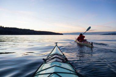 Deniz Kanosundaki Macera Adam canlı ve renkli kış günbatımında kayak yapıyor. Vancouver, British Columbia, Kanada 'da çekilmiş. Macera, Tatil Konsepti