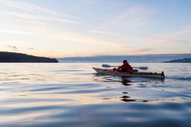 Deniz Kanosundaki Macera Adam canlı ve renkli kış günbatımında kayak yapıyor. Vancouver, British Columbia, Kanada 'da çekilmiş. Macera, Tatil Konsepti