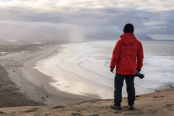 有摄像头的冒险男人正站在一个充满活力的冬季日出的美丽海滩拍照 Kiwanda 太平洋城市 俄勒冈州海岸 — 图库照片