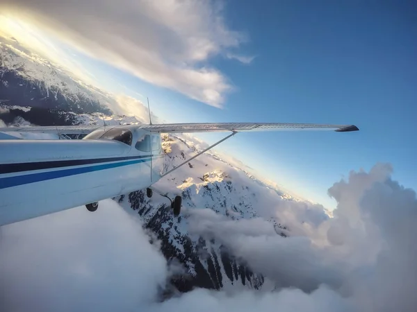 在充满活力的日落期间 飞越加拿大山地景观的小型飞机 在加拿大不列颠哥伦比亚省温哥华以北的 Squamish 附近拍摄 — 图库照片