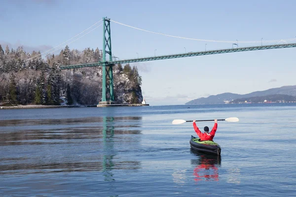 Adventurous man kayaking on an inflatable kayak near Lions Gate Bridge. Taken in North Vancouver, British Columbia, Canada.