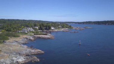 Havadan görünümü güzel bir Pasifik Okyanusu sahne ile kayalık sahil üstünde lüks evler. Sermaye Şehir Victoria içinde Vancouver Adası, British Columbia, Kanada, gündoğumu sırasında alınan.