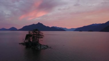 Canlı bir gün batımı sırasında arka planda dağlar ile güzel bir ada Cinemagraph animasyon. Howe ses, Vancouver, British Columbia, Kanada kuzeyindeki alınan.