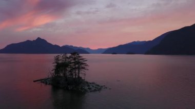 Canlı bir gün batımı sırasında arka planda dağlar ile güzel bir ada Cinemagraph animasyon. Howe ses, Vancouver, British Columbia, Kanada kuzeyindeki alınan.