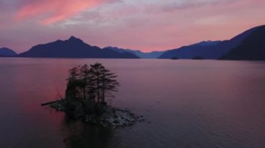 Bir ada okyanus güzel giriş peyzaj dağlarla çevrili arka planda ile hava doğal görünümünü. Howe ses, Kuzey Vancouver, British Columbia, Kanada, günbatımı sırasında alınan.